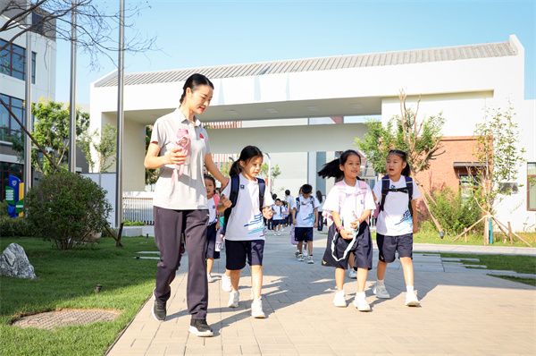 8月30日，雄安史家胡同小学学生体验学校生活。老师带学生进教室。