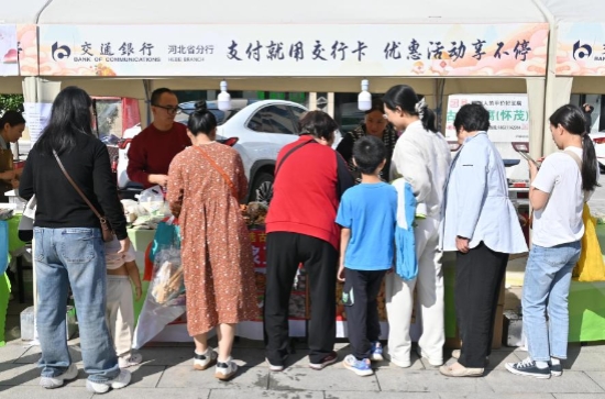 市民在摊位上品尝、购买特色农产品。实习生 赵英杰摄