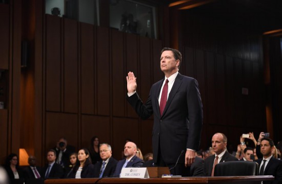 2017年6月8日，在美国华盛顿，美国联邦调查局（FBI）前局长詹姆斯·科米（前）在国会参议院出席听证会前宣誓。新华社记者殷博古摄