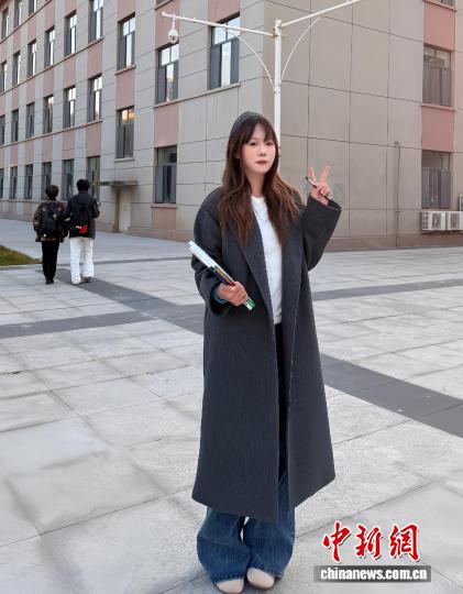 刘沫含在宿舍前拍照,她身着“双十一”花200多元买的风衣。 受访者供图