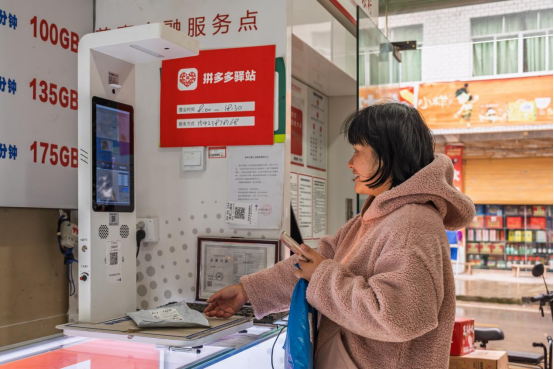 ▲村民通过拼多多驿站自助取货系统取快递。李雨恒 摄