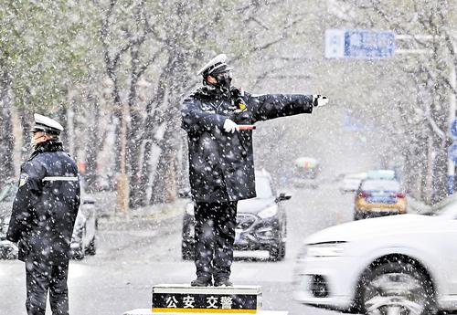 12月12日,在石家庄市裕华东路和青园街交叉口,交警冒雪疏导交通。本报记者 贾 恒摄