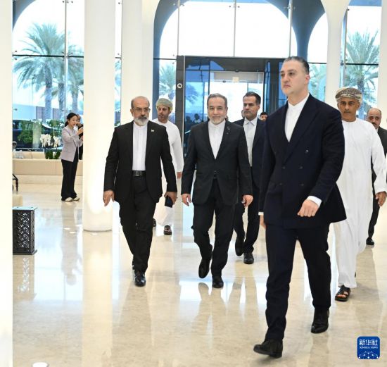 2月6日，在阿曼首都马斯喀特，伊朗外长阿拉格齐（中）结束谈判后返回下榻酒店。新华社发