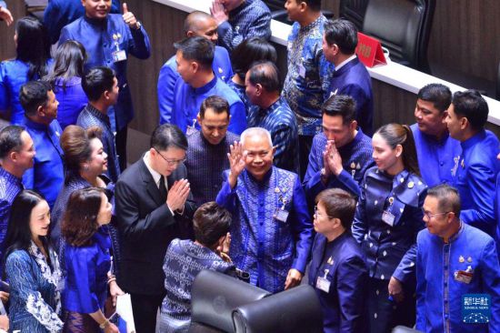 3月15日,泰国自豪泰党议员梭蓬·乍兰(中)在曼谷国会下议院庆祝当选。新华社发(拉亨摄)