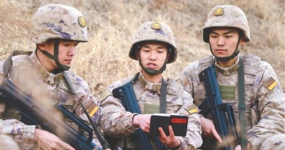 何加伟(中)利用《战斗日志》与战友探讨战术。孙梓菡摄