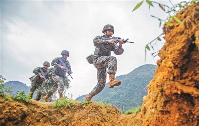 武警广西总队河池支队组织官兵开展军事体育强化训练，增强官兵体能素质。图为官兵跨越战壕。刘 坚摄
